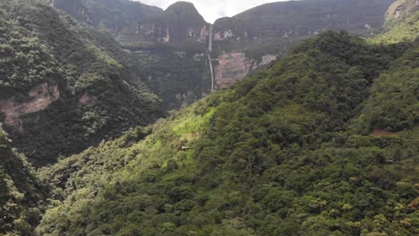 drone shot of the gocta falls in the amazon of peru from far away flying toward the falls