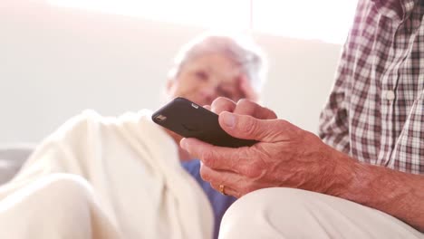 Mature-couple-using-smartphone-on-the-couch