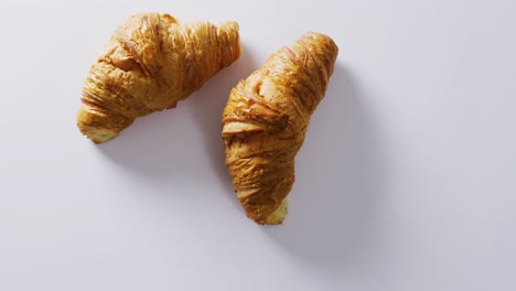 Video-of-close-up-of-croissants-with-copy-space-on-white-background