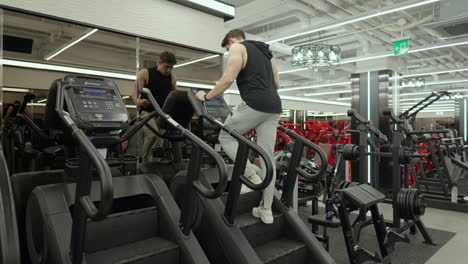 Un-Hombre-Musculoso-Y-Atractivo-Haciendo-Ejercicio-En-Máquinas-Stepmill-En-El-Gimnasio