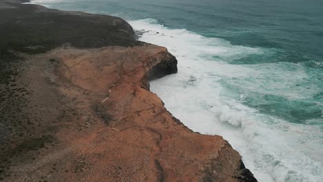 Toma-Aérea-De-Mareas-Golpeando-El-Terreno-Elevado-Formando-Ondas-En-Cape-Bridgewater,-Australia