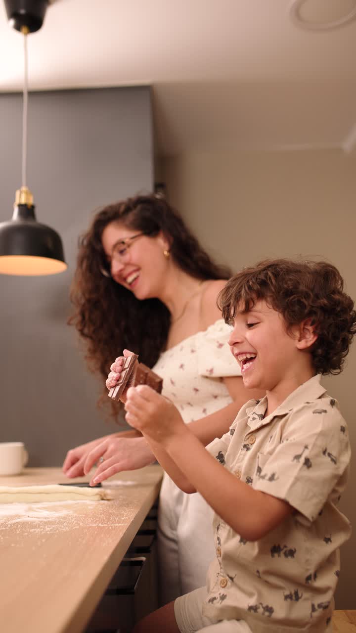 Mother and son baking cookies together in modern kitchen