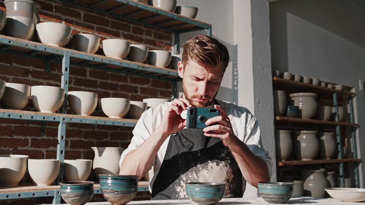 Uomo che fotografa ceramiche in un laboratorio