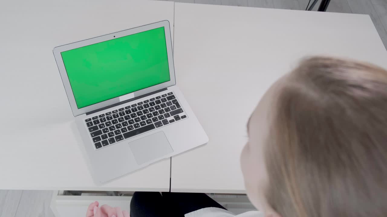 hay una computadora portátil con una pantalla verde en la mesa. consulta médica en línea.