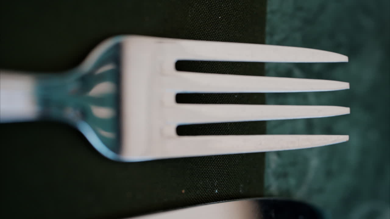 Close up of a fork on a green napkin. Vertical