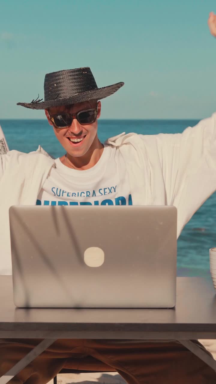 hombre trabajando en una computadora portátil en la playa