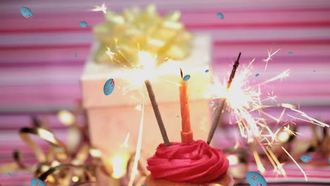 animation of balls with great britain flags over hand lightening candles and fireworks on cake