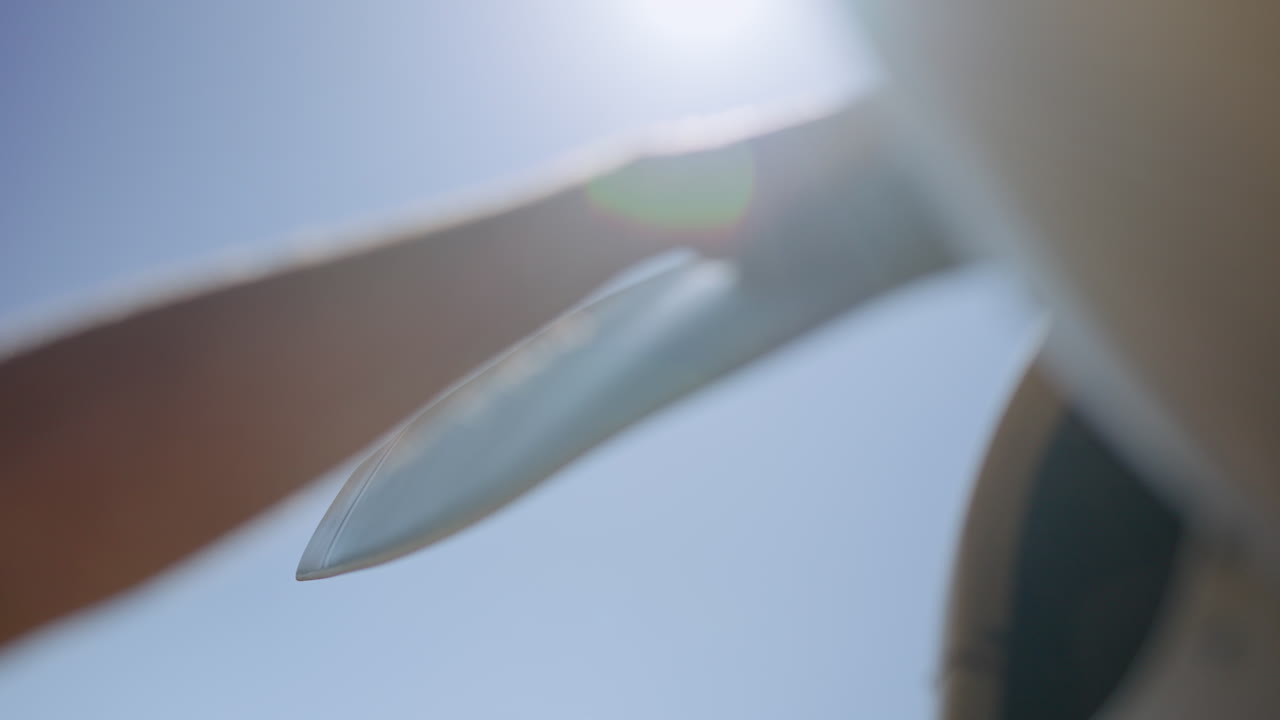 Hand Touching and Spinning an Aircraft Propeller Blade Against Blue Sky