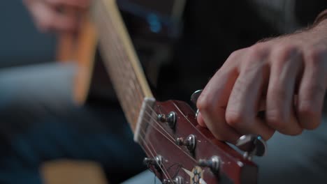 person tuning a guitar