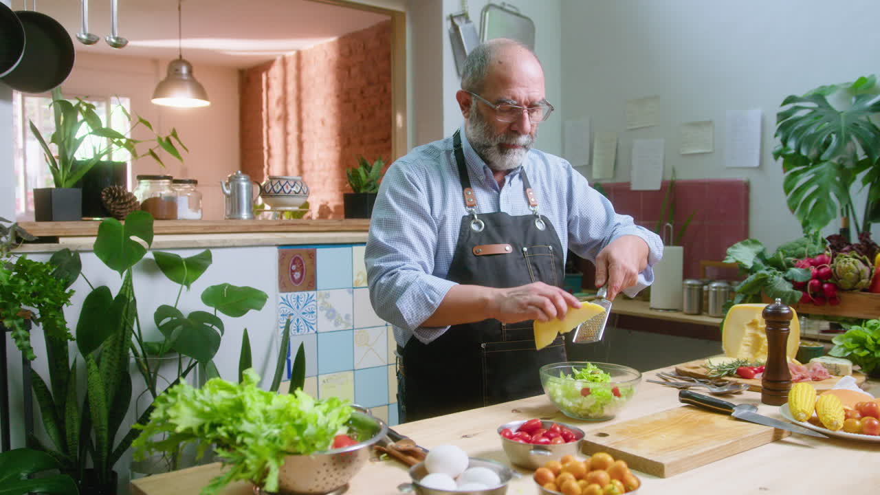 Man preparing a salad with cheese in the kitchen