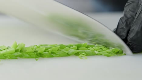 cook cuts green onions with a knife