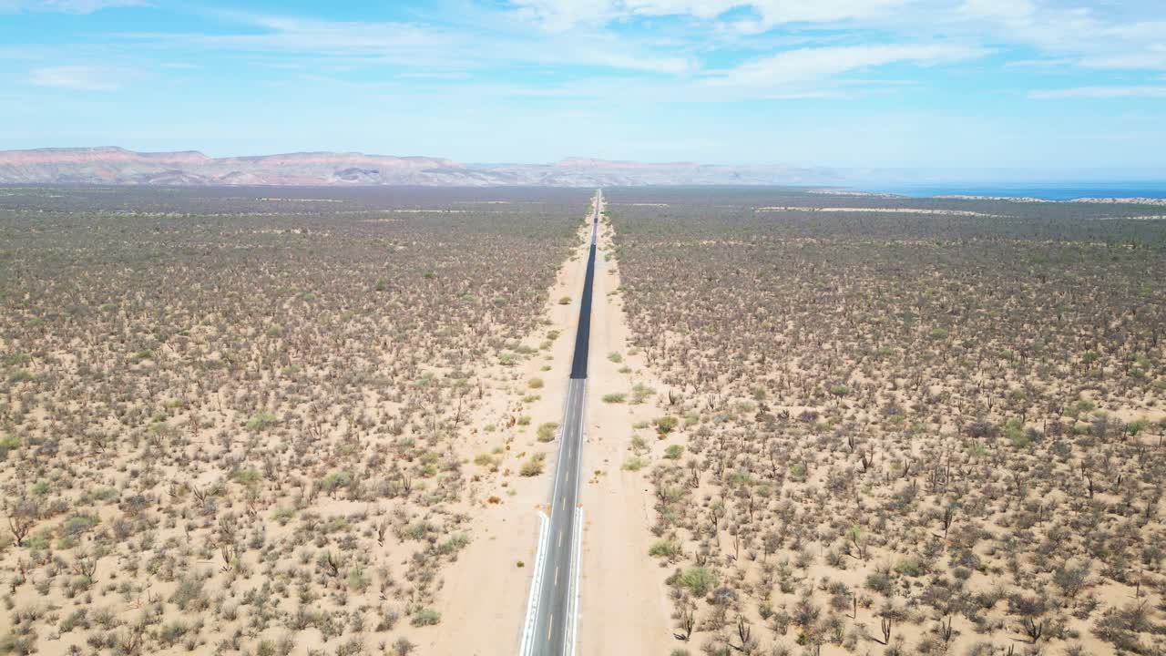 Long, straight road cutting through the desert landscape near La Paz, El Mogote, Mexico