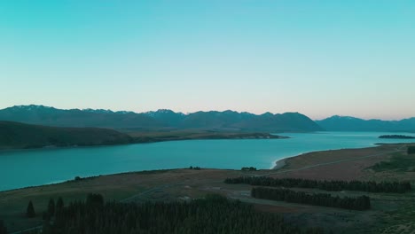 drone aerial of lake tekapo both sides of lake with mountian range in background