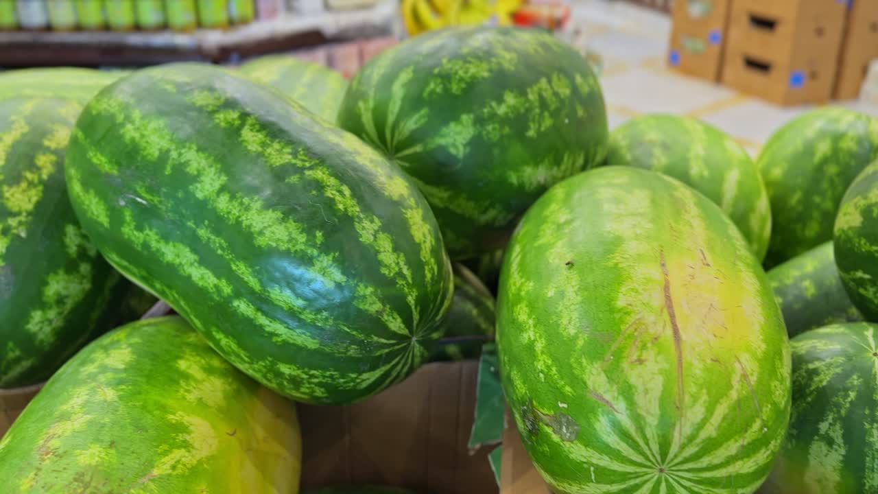 Crisp 4K close-up of ripe green watermelons stacked in a market. Perfect for food, farming, retail, or summer themes. Ideal for advertising, nutrition, and grocery concepts.