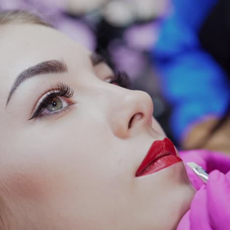 healthy spa. young beautiful woman having permanent make-up tattoo on her lips. video of the process