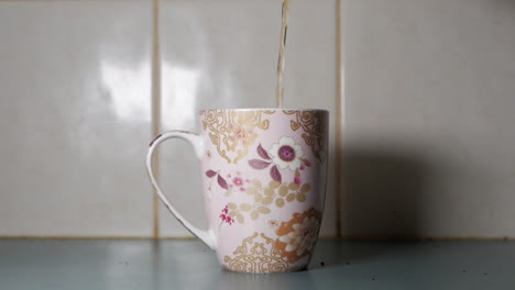 té que se vierte en una taza de té decorativa