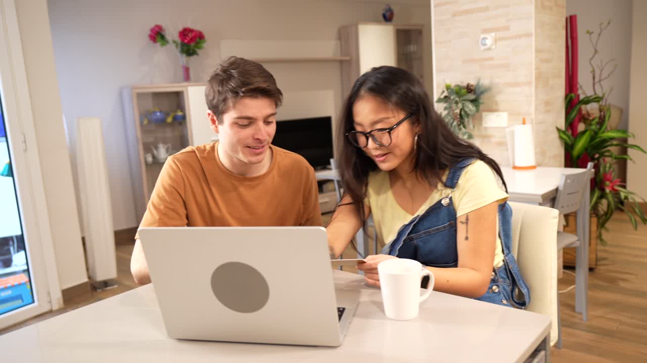 Couple shopping online with laptop at home
