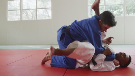 judokas luchando e inmovilizando en el suelo