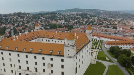 Toma-Aérea-En-órbita-Sobre-El-Castillo-De-Bratislava-Revela-El-Paisaje-Urbano-En-Segundo-Plano