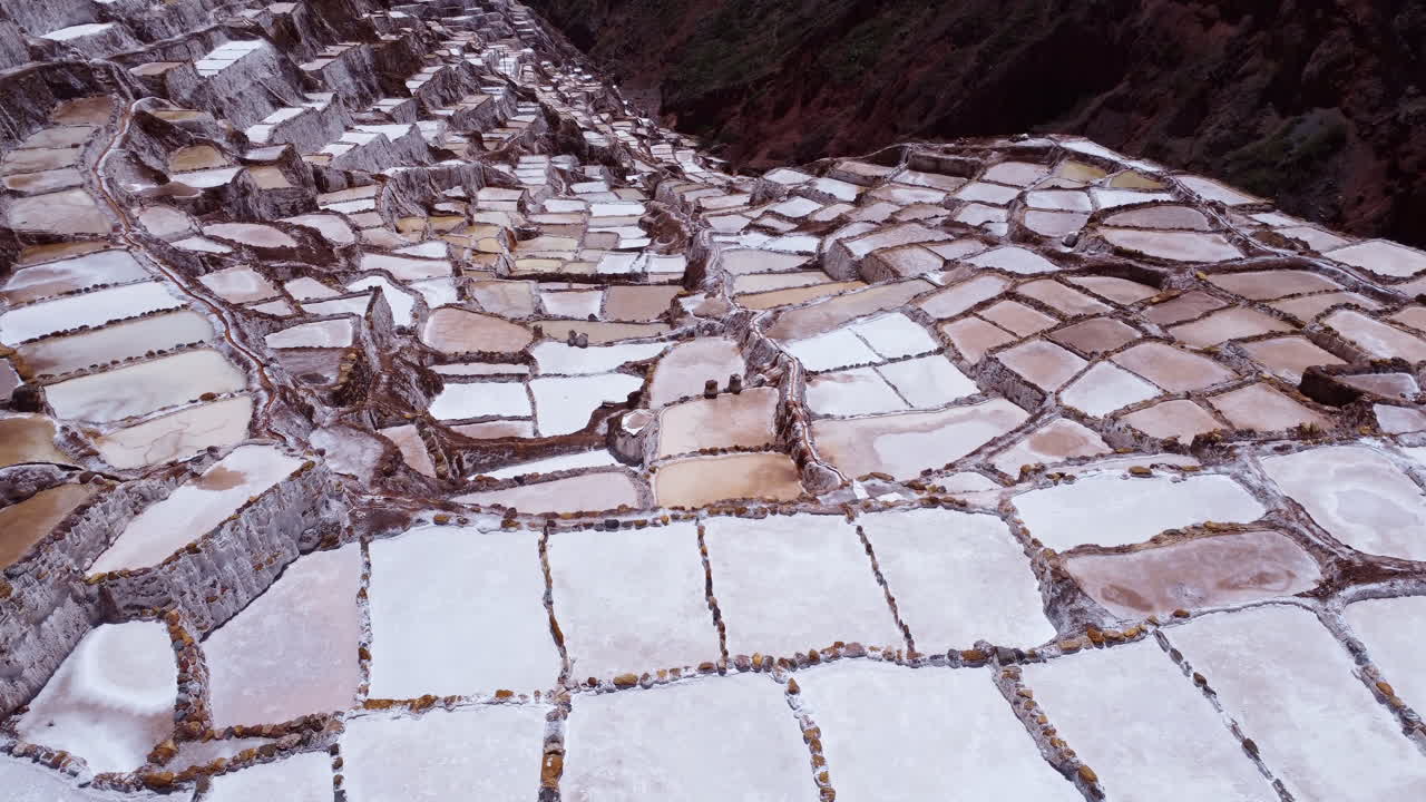 las minas de sal de maras en el valle sagrado de perú, dolly aérea sobre piscinas alineadas con rocas