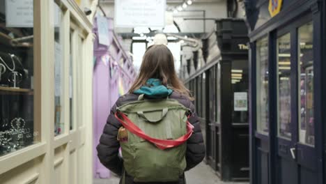 young woman walks inside a shopping gallery