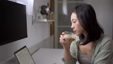 asian writer with laptop and coffee at home