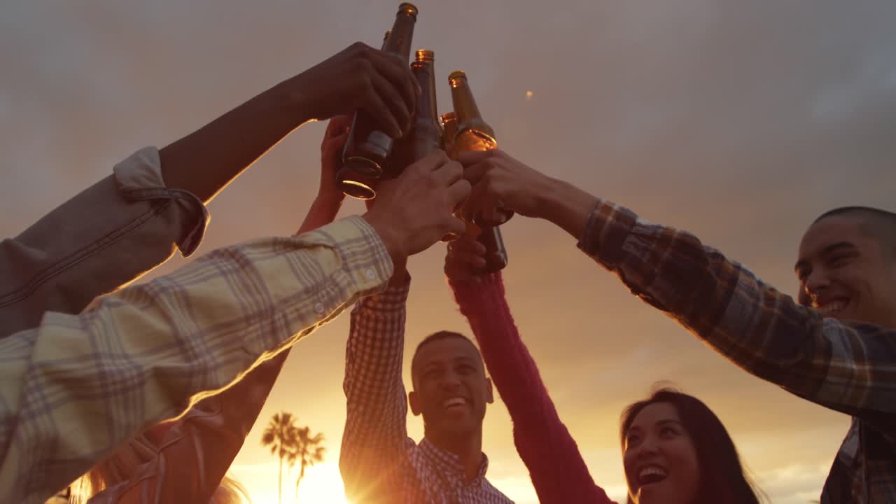 Gruppo di amici che bevono una birra su un tetto