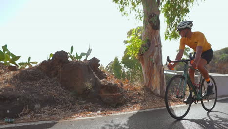 In-the-morning,-a-man-takes-his-road-bike-for-a-spin-on-an-unoccupied-road,-engaging-in-outdoor-exercise.-The-slow-motion-capture-highlights-the-spirit-of-extreme-sports