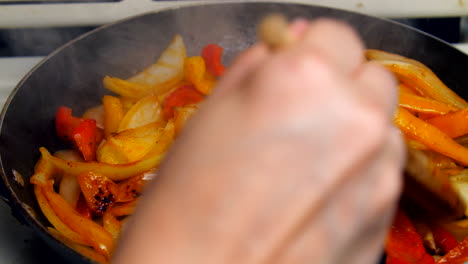 bell peppers and onions simmer in a hot pan