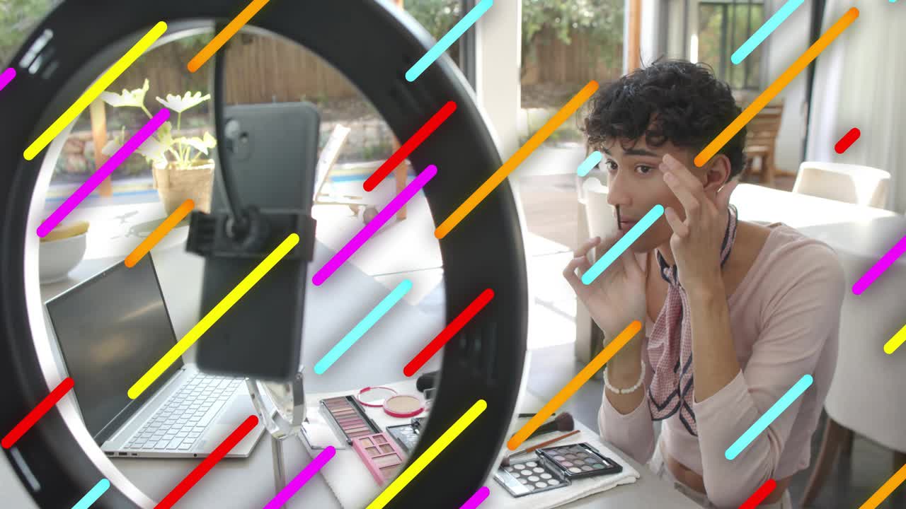 Male beauty vlogger arranging at ring light phone, doing eye makeup for tutorial, stripes showing