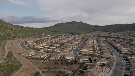 un drone deslizante lento ilumina sutilmente un vecindario de riverside, california bajo la difusión de un cielo nublado.