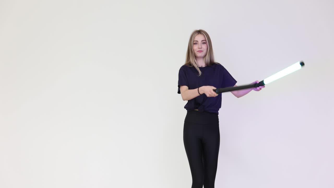 Una donna in leggings neri e maglietta balla con lampade ultraviolette.