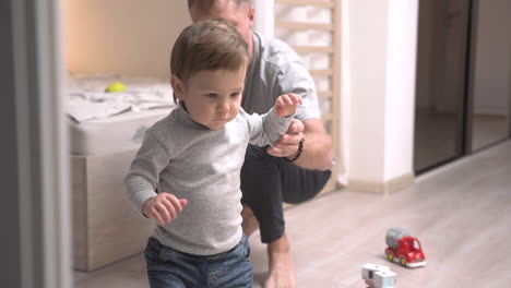padre sosteniendo a su hijo y lo pone en el suelo