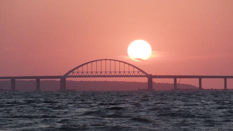 sunset over a bridge at the ocean