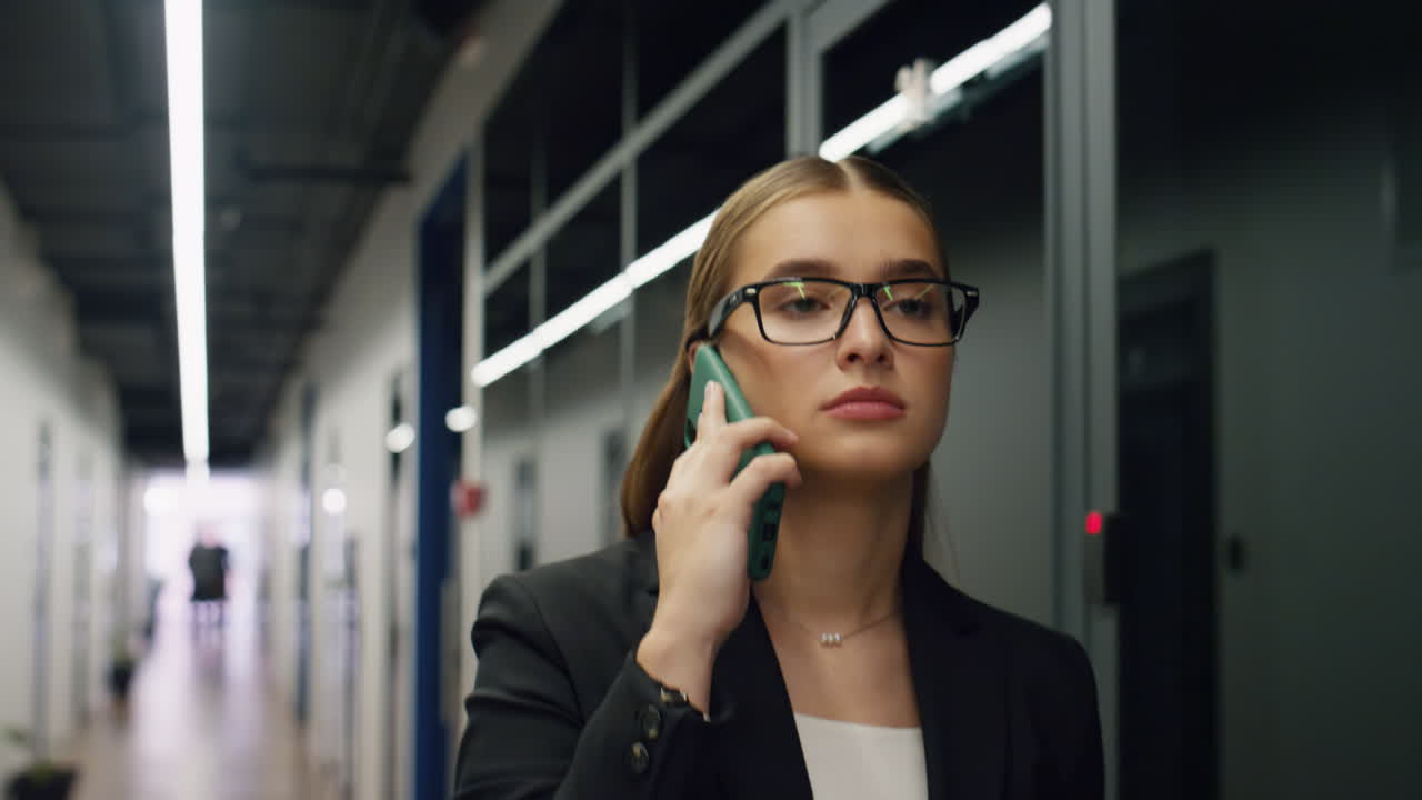 Confident manager speak smartphone corridor closeup. Beautiful ceo walk office