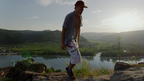 cool-guy,-mountain-landscape,-river-danube-in-background,-sunny-weather,-travelling-man,-hike-trail-path-to-the-horizon,-sunny-valley-austria,-travel-freedom,-free-living,-relaxation,-digital-detox