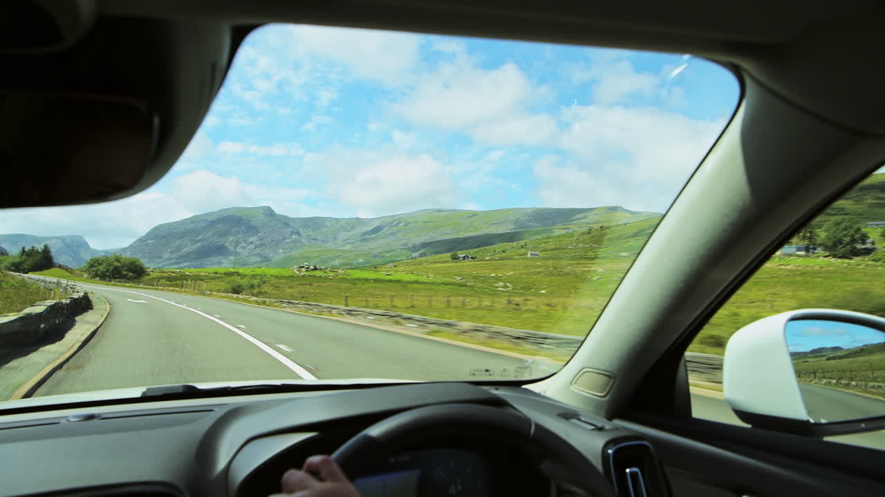 Driving through Snowdonia National park with stunning mountains, inside car view