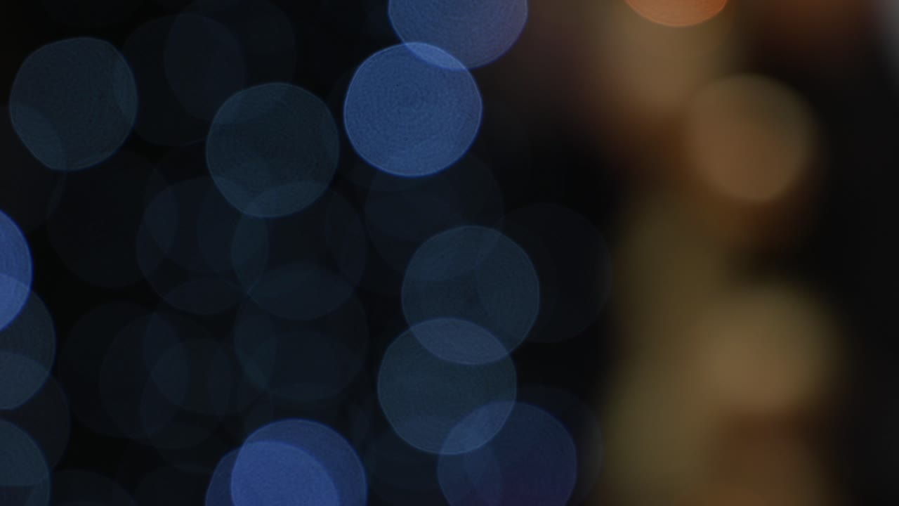 Blurred view of blue Christmas lights on a black background