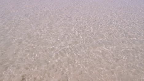 surface-texture-of-the-wave-from-calm-sea-on-the-white-sand-beach-in-summer-sunshine-time