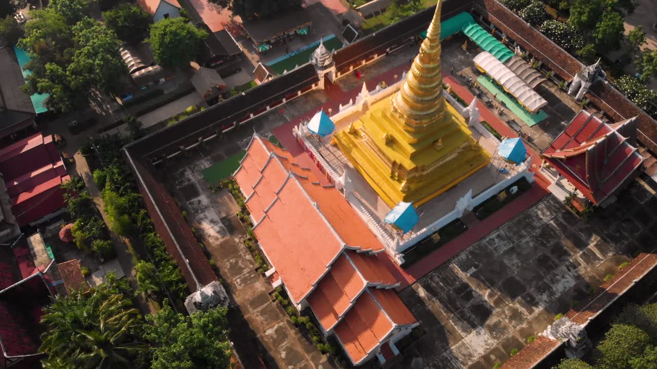 4k Thai golden temple drone shot revealing background at Naan province, Thai traditional culture, Thai Buddhism asia travel destination, peaceful calm scenic, non-urban, camera tilt up and dolly out