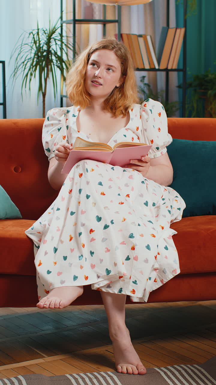 Redhead woman relaxing interesting book turning pages smiling enjoying literature taking a rest