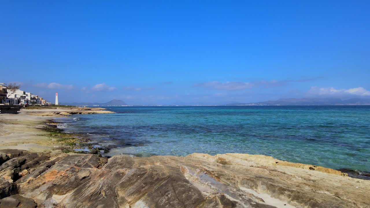 Explore the captivating sculptures placed along the sandy shores of Son Baulo, highlighting the stunning beauty of Can Picafort. Enjoy the tranquil atmosphere under a clear blue sky.