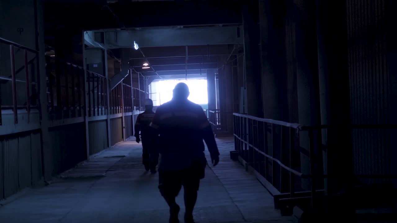 어두운 산업 터널 을 걸어가는 노동자 들