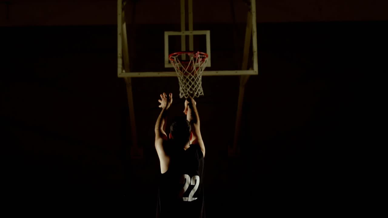 jugador de baloncesto masculino lanzando baloncesto en el aro de baloncesto 4k