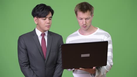 young handsome asian businessman and young scandinavian businessman working together