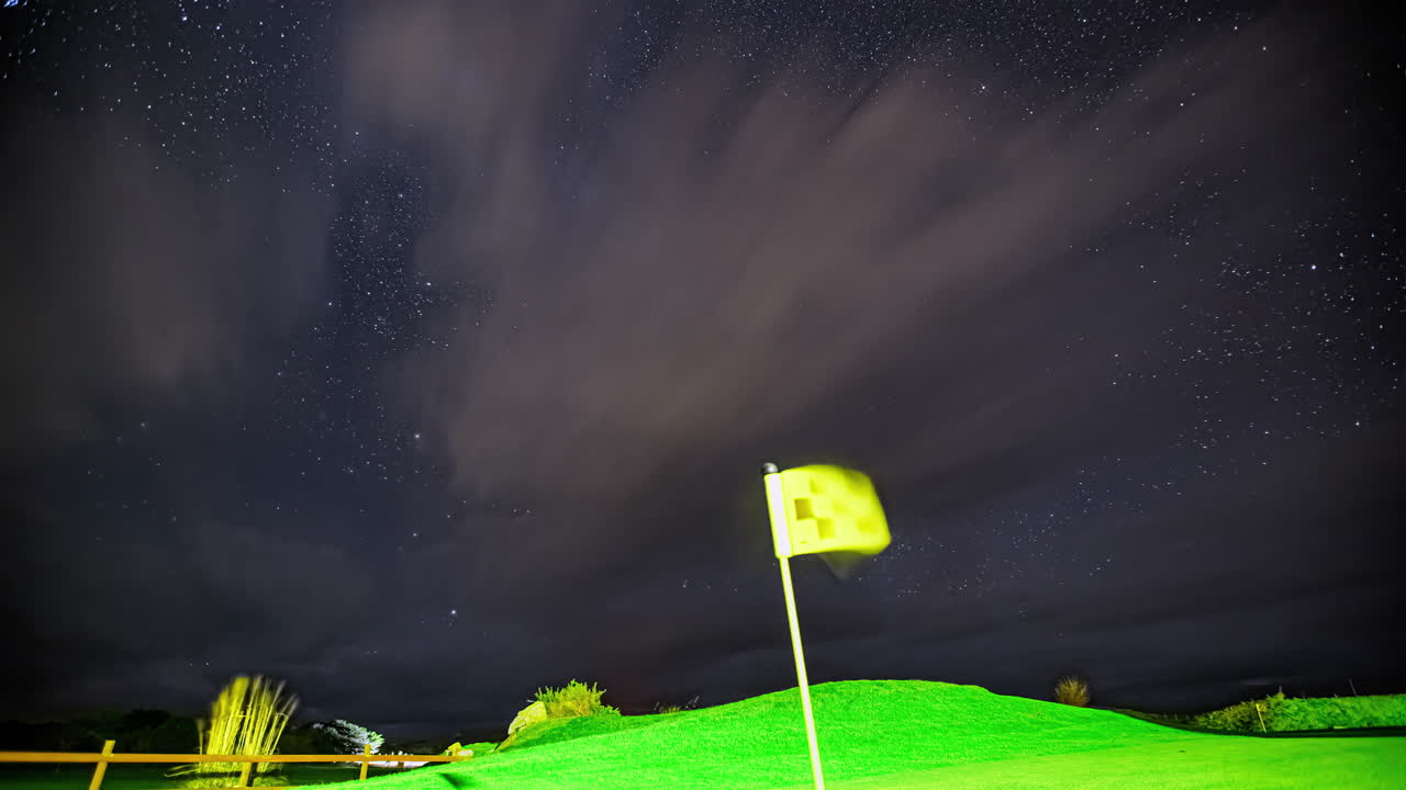 hiperlapso de nubes voladoras y estrellas en el cielo nocturno sobre la cancha de golf