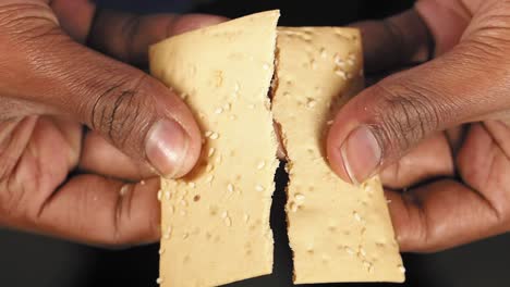 hands holding crackers with sesame seeds