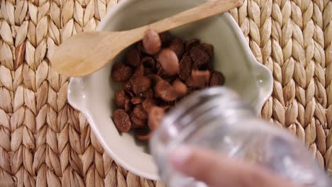 mano derramando copos de chocolate en un cuenco 4k