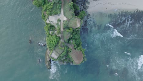 top down drone shot over tropical balangan beach peninsula in uluwatu bali indonesia with crashing waves and turquoise water