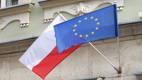 flags of poland and the european union, polish flag and ue flag together, object closeup, nobody, slow motion. nato countries alliance protection political treaty symbol abstract concept, no people